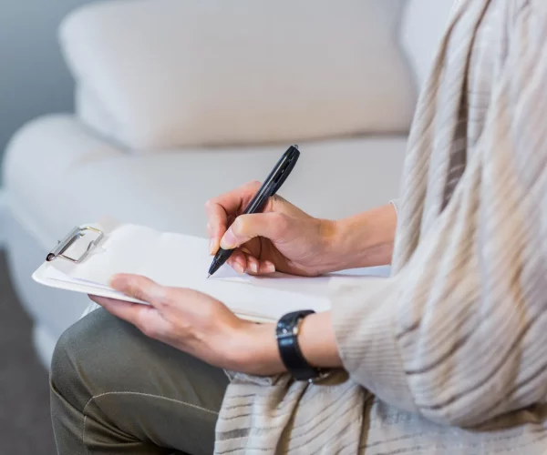 psychotherapist-sitting-on-the-couch-and-taking-notes